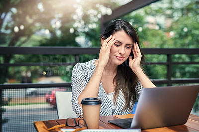 Buy stock photo Cropped shot of an attractive young businesswoman looking stressed while working on her laptop at a cafe