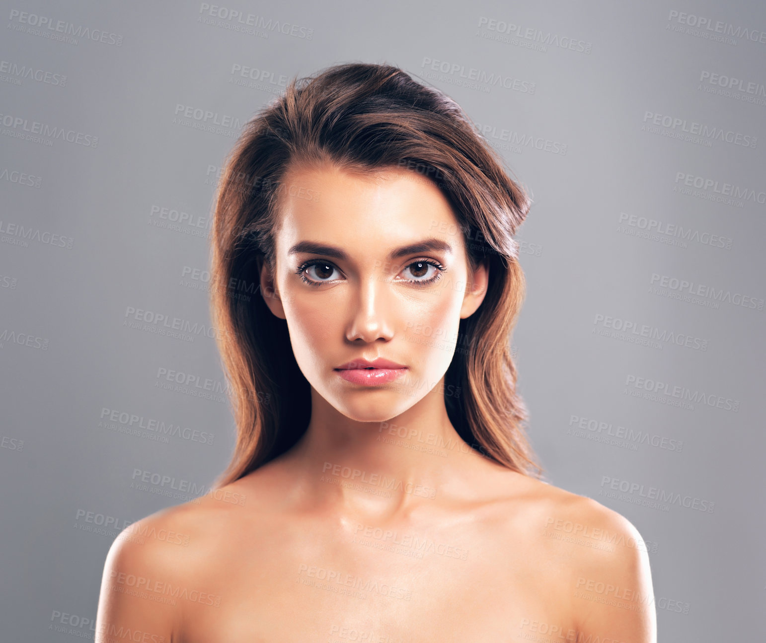 Buy stock photo Studio shot of a beautiful young woman posing against a gray background