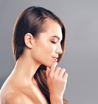 Buy stock photo Studio shot of a beautiful young woman posing against a gray background