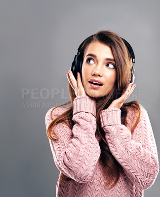 Buy stock photo Studio shot of a beautiful young woman listening to music against a gray background