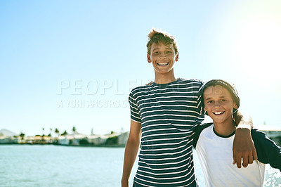 Buy stock photo Cropped portrait of two young brothers standing outside with a lagoon in the background
