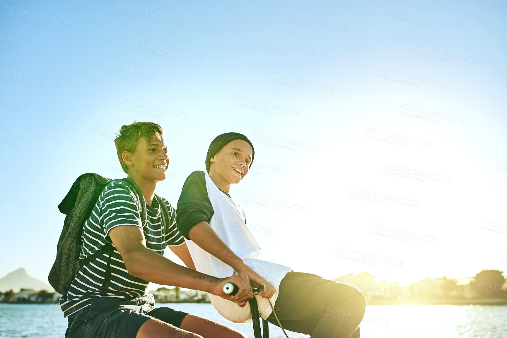 Buy stock photo Cropped shot of a young boy giving his younger brother a lift on a bicycle outside