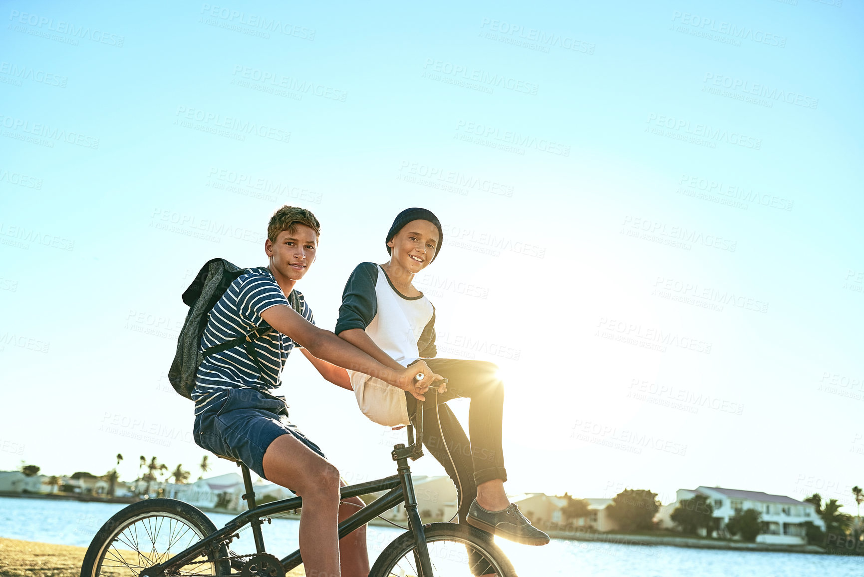 Buy stock photo Outdoor, portrait and boys with bicycle for riding, paddle and coordination with balance for brothers. Lagoon, children and siblings with bike for transport, travel and bonding together in nature