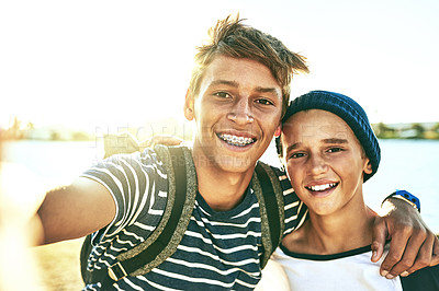 Buy stock photo Cropped portrait of two young brothers taking selfies outside with a lagoon in the background