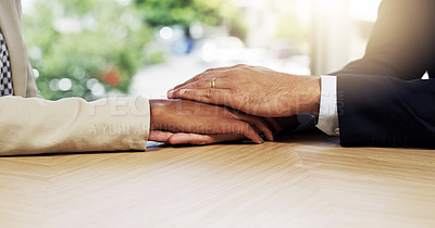 Buy stock photo Closeup shot of two unidentifiable colleagues holding hands in an office