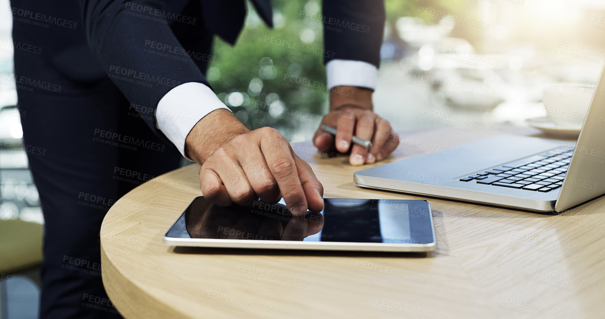 Buy stock photo Closeup shot of an unidentifiable businessman using a digital tablet and laptop in an office