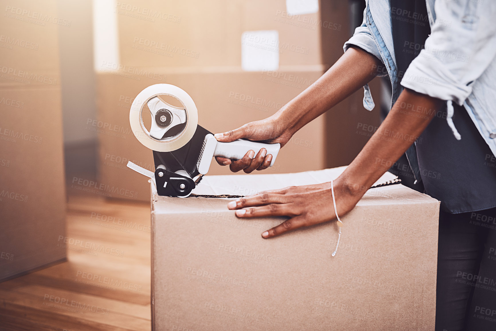 Buy stock photo Cropped shot of an unrecognizable woman packing boxes getting ready to move