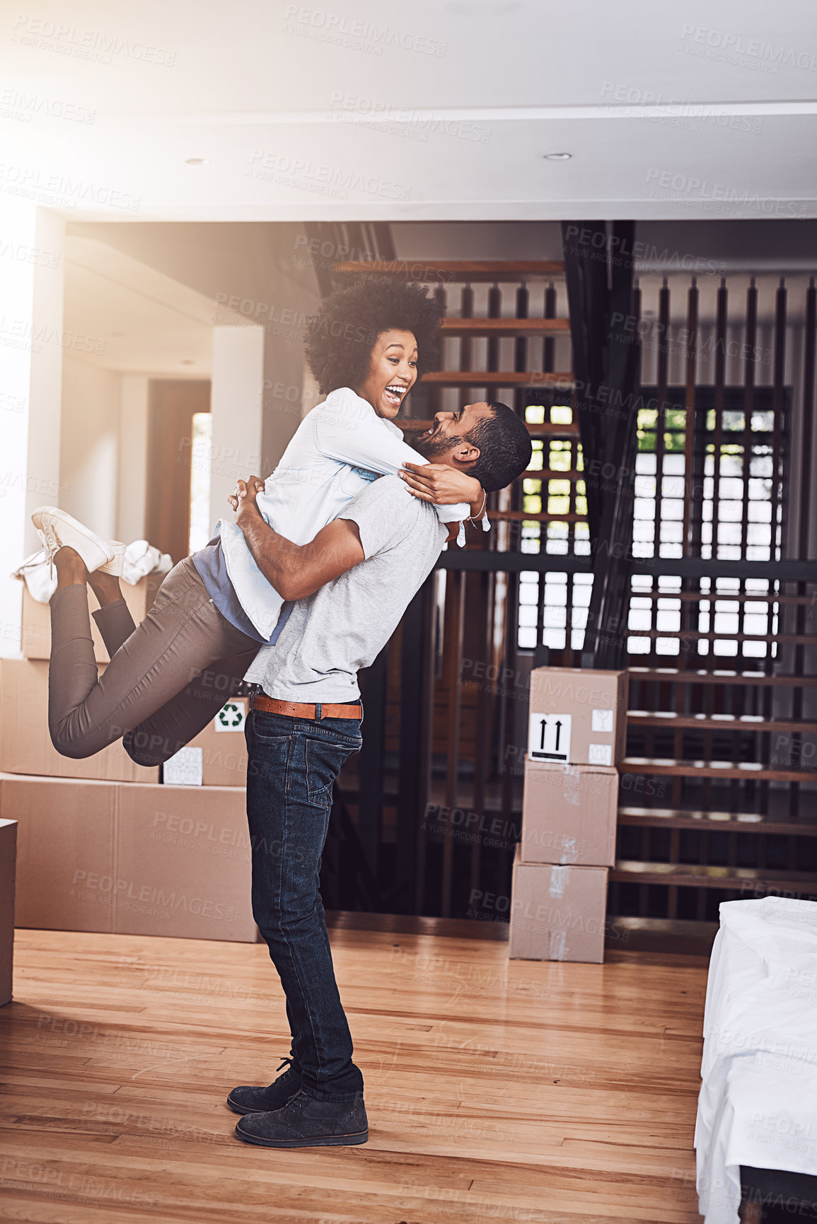 Buy stock photo Shot of an affectionate young couple moving into their new home