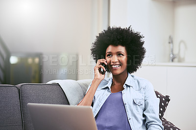 Buy stock photo Shot of a young woman using a laptop and mobile phone on the sofa at home