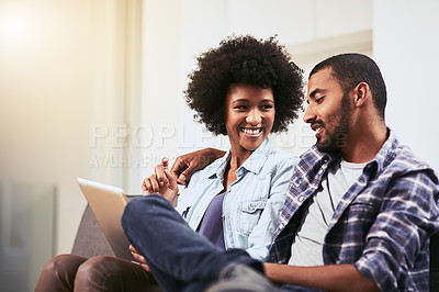 Buy stock photo Shot of a young couple using a digital tablet together on the sofa at home