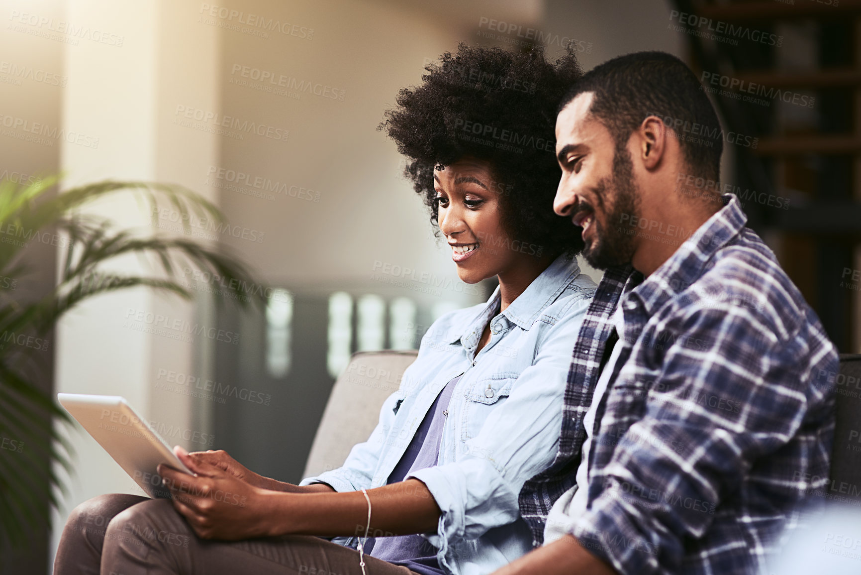 Buy stock photo Tablet, smile and couple relax in home for online streaming, movie or show on app. Technology, man and interracial woman in living room for to watch video, subscription service or scroll social media
