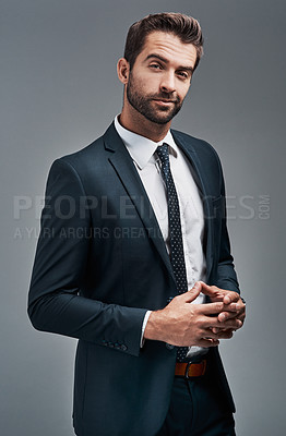 Buy stock photo Studio portrait of a handsome young businessman posing against a grey background