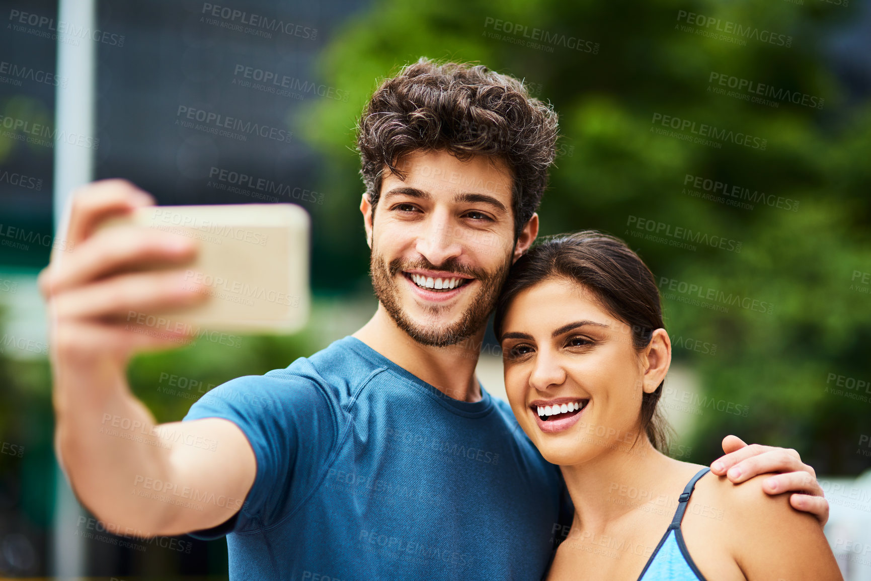 Buy stock photo Shot of a sporty young couple taking a selfie together outdoors