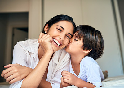 Buy stock photo Happy mother, child and kiss with love on bed for bonding, moment or holiday together at home. Mom, little boy and kid with smile for embrace, weekend or motherhood affection on cheek in bedroom