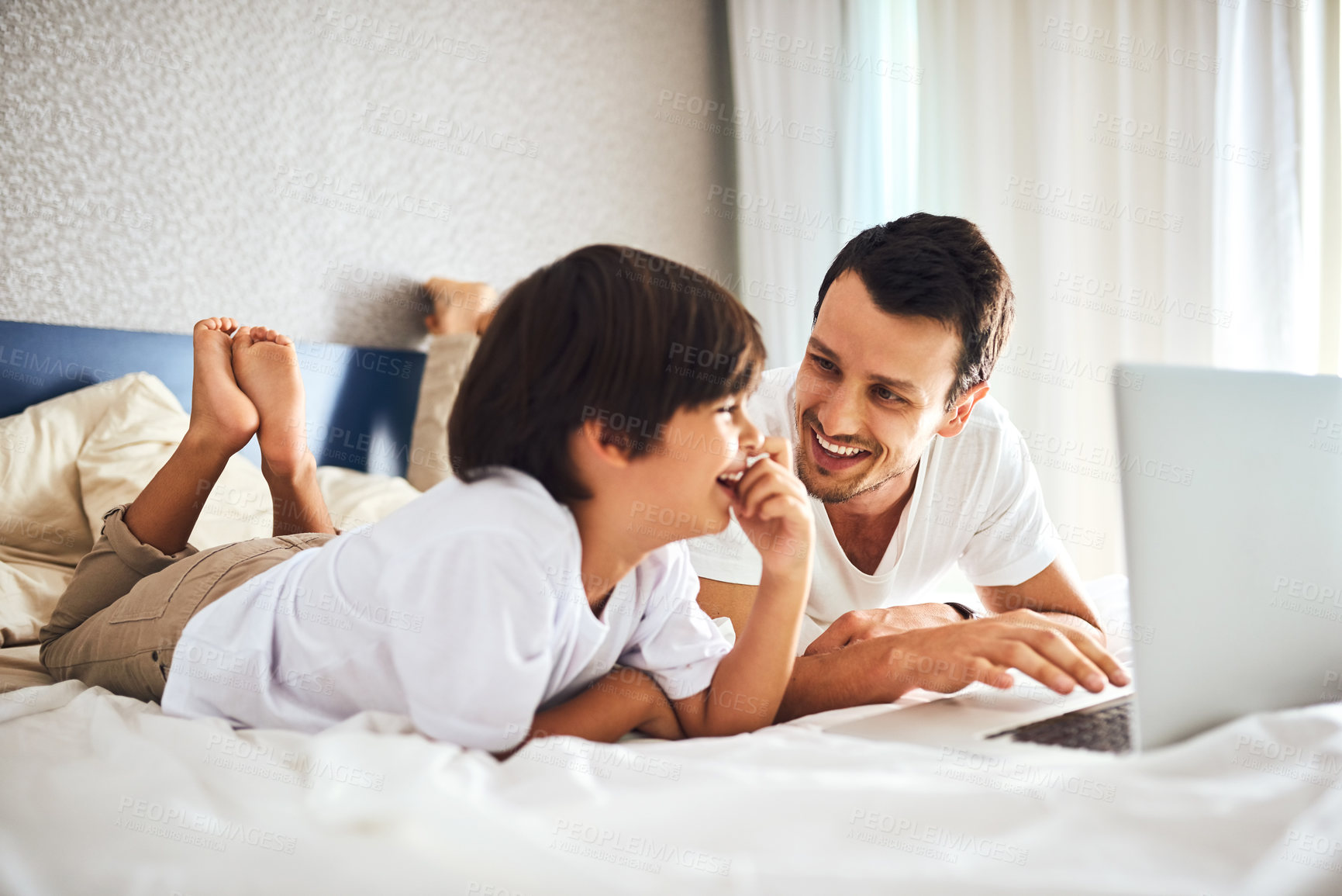Buy stock photo Shot of a father and his little son using a laptop together at home