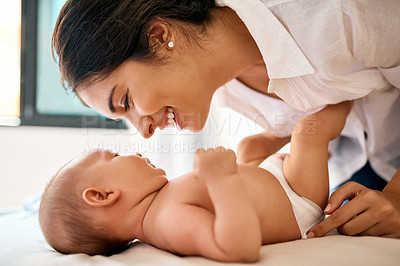 Buy stock photo Shot of a happy mother bonding with her baby boy at home