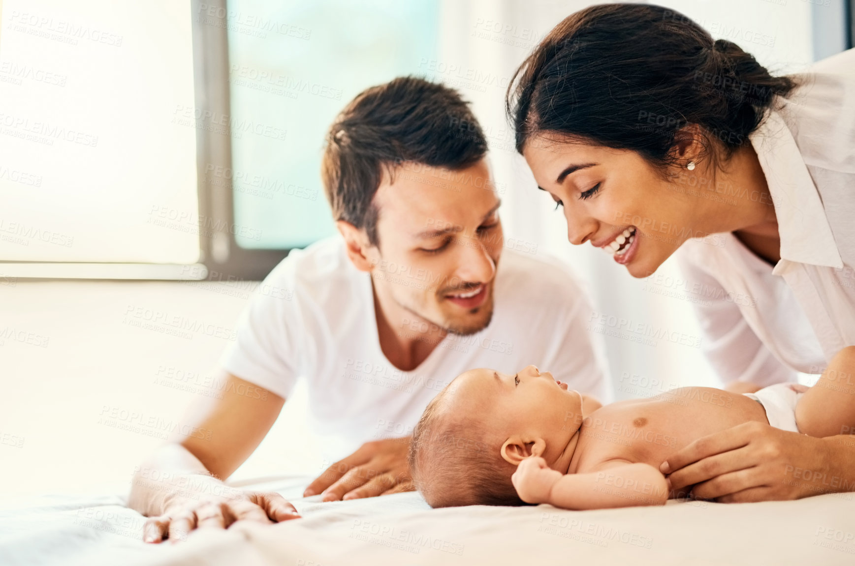 Buy stock photo Shot of a happy mother and father bonding with their baby boy at home