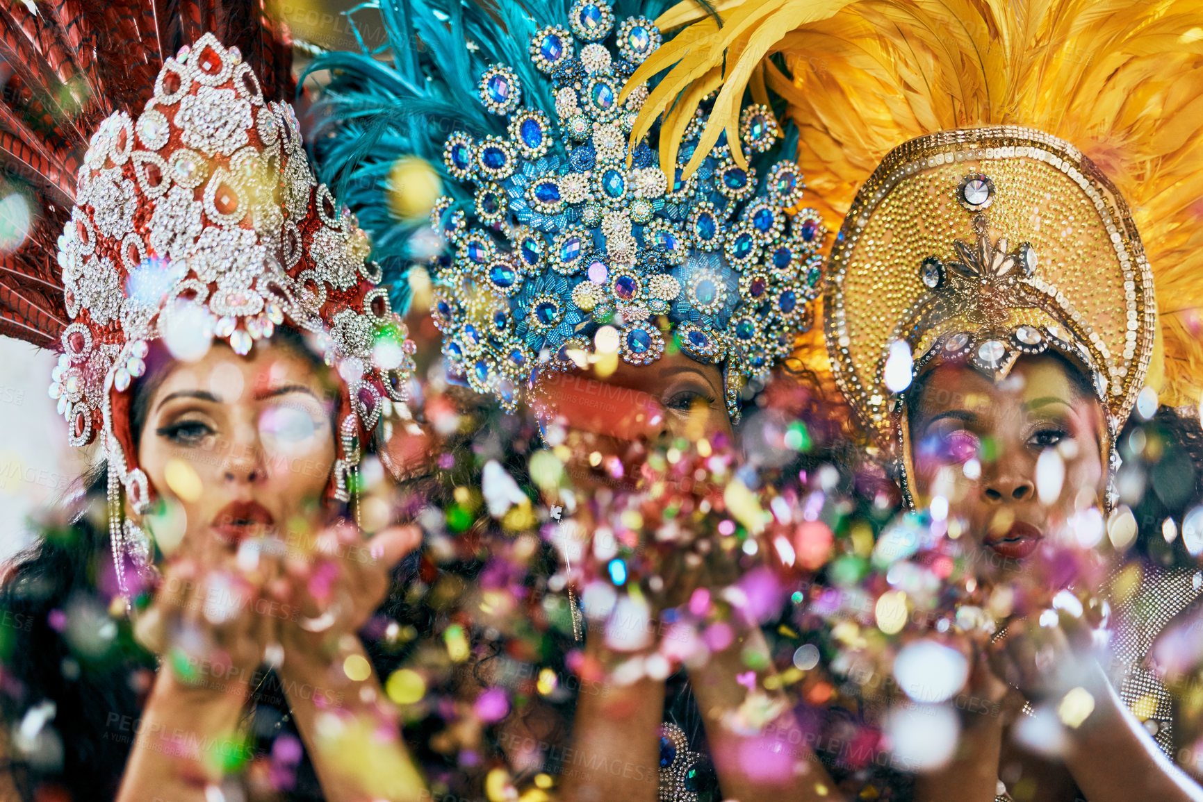 Buy stock photo Cropped shot of beautiful samba dancers blowing confetti from their hands in a carnival