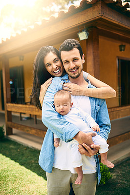 Buy stock photo Cropped portrait of a happy young family of three outside with their house in the background