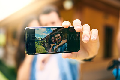 Buy stock photo Happy couple, hug and phone screen for selfie, photo or profile picture together in relationship outdoors. Hand of man holding smartphone with woman hugging for love, memory or capture outside home