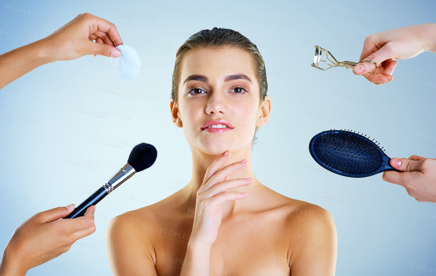 Buy stock photo Studio portrait of a beautiful young woman with an assortment of beauty tools around her against a blue background