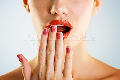 Buy stock photo Cropped studio shot of a beautiful young woman wearing red lipstick looking surprised against a gray background