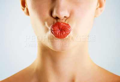 Buy stock photo Cropped studio shot of a beautiful young woman wearing red lipstick and pouting against a gray background