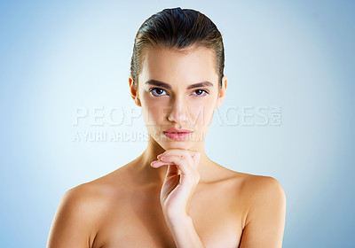 Buy stock photo Studio portrait of a beautiful young woman posing against a blue background