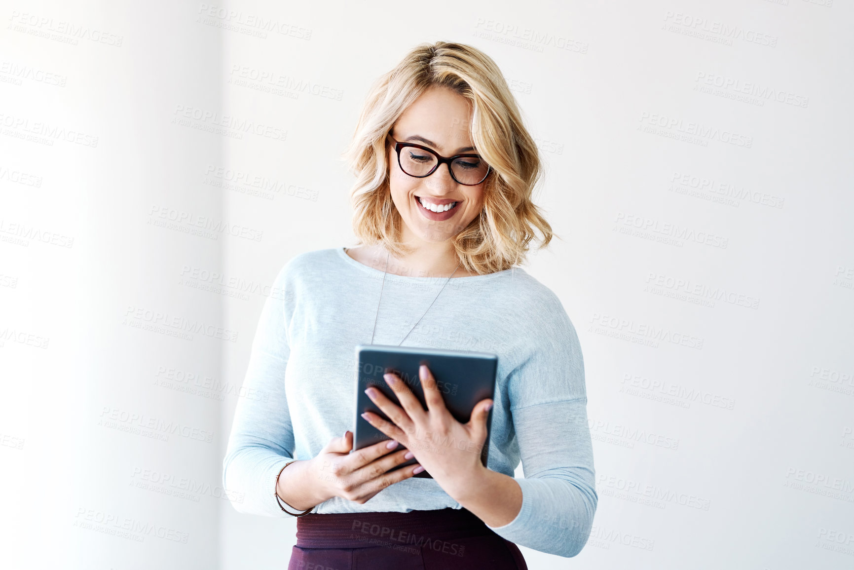 Buy stock photo Shot of an attractive young businesswoman using a digital tablet in an office