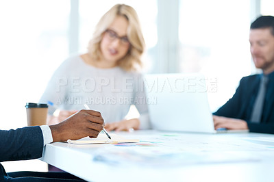 Buy stock photo Closeup shot of an unrecognizable businessman writing notes while in a meeting with his colleagues