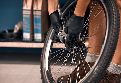 Buy stock photo Cropped shot of a man repairing a bicycle in a workshop