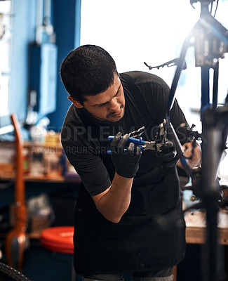 Buy stock photo Shot of a man working in a bicycle repair shop