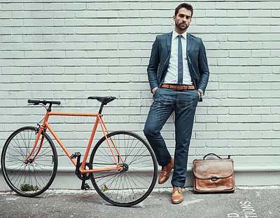 Buy stock photo Business man, street and portrait with bicycle b wall, commute or sustainable travel in city. Person, suit and bike for eco friendly transportation on urban sidewalk, road and leather bag in New York