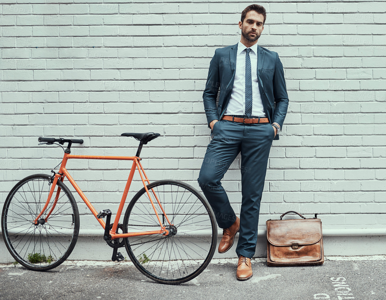 Buy stock photo Portrait of a handsome young businessman standing alongside his bike outdoors