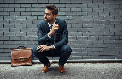 Buy stock photo Shot of a handsome young businessman posing against a grey wall outdoors