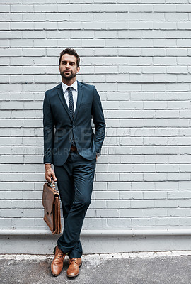 Buy stock photo Shot of a handsome young businessman posing against a white wall outdoors