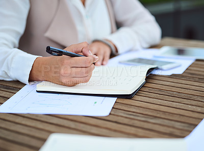 Buy stock photo Cropped shot of an unrecognizable young businesswoman taking notes while sitting in her office