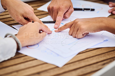Buy stock photo Cropped shot of a group of unrecognizable businesspeople pointing at paperwork during a meeting in the boardroom