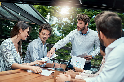 Buy stock photo Shot of a group of colleagues having a meeting at a cafe