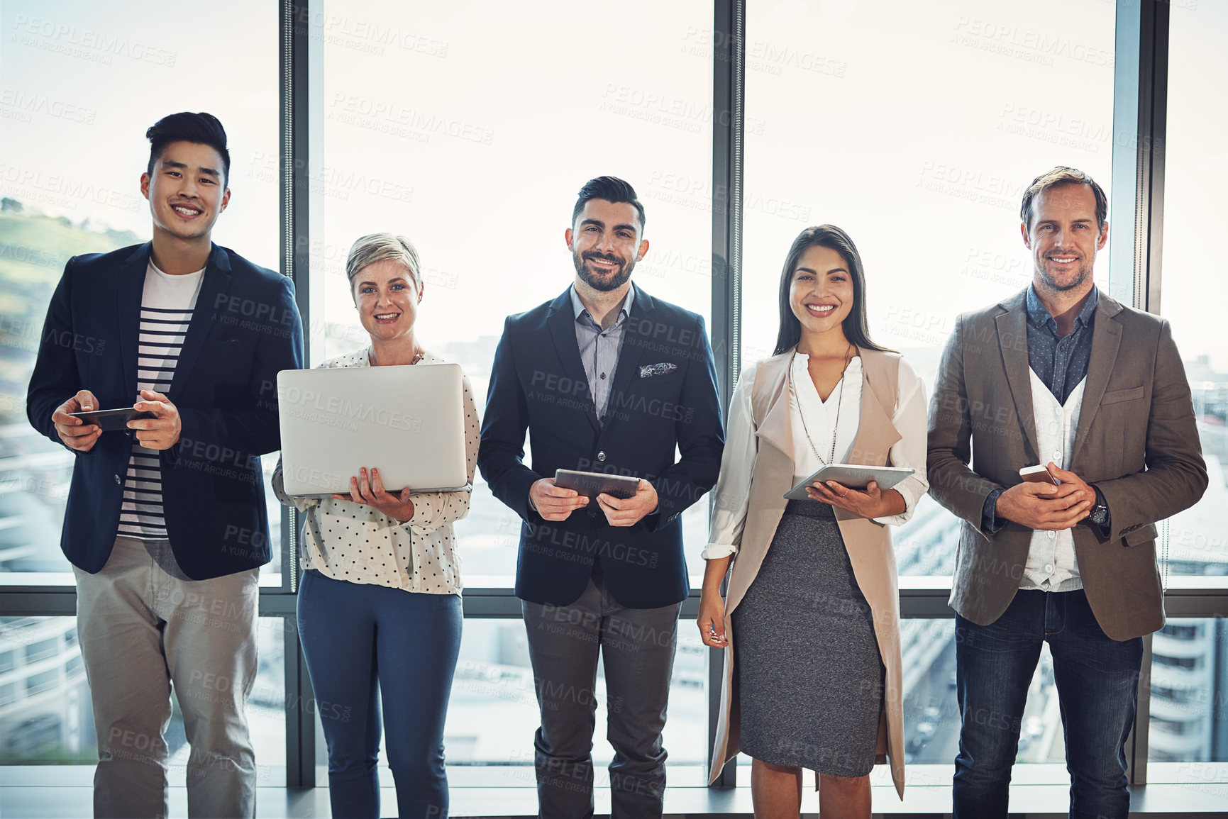 Buy stock photo Portrait of a diverse group of businesspeople using wireless technology in an office