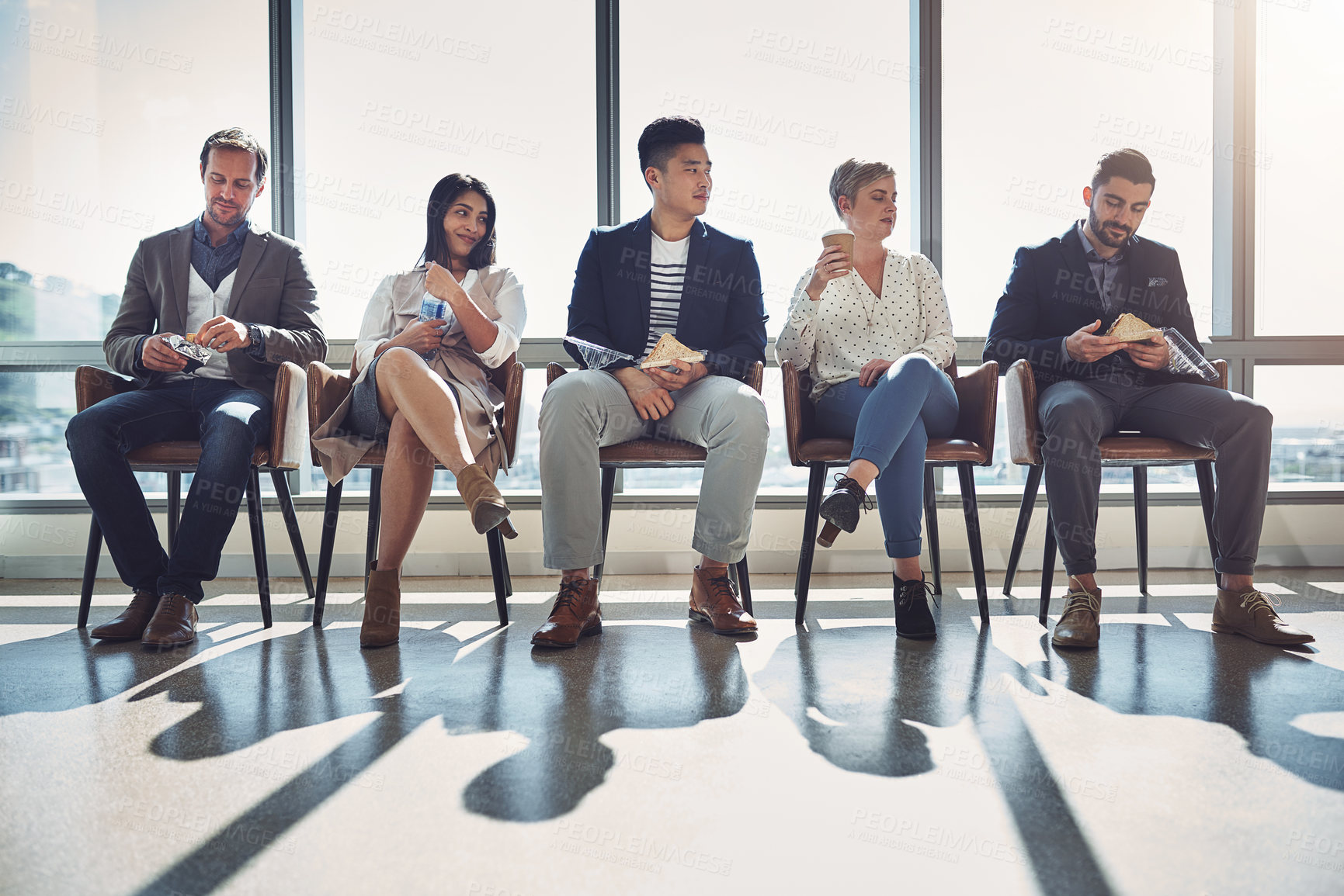 Buy stock photo Shot of a group of businesspeople taking a break while sitting in line in an office