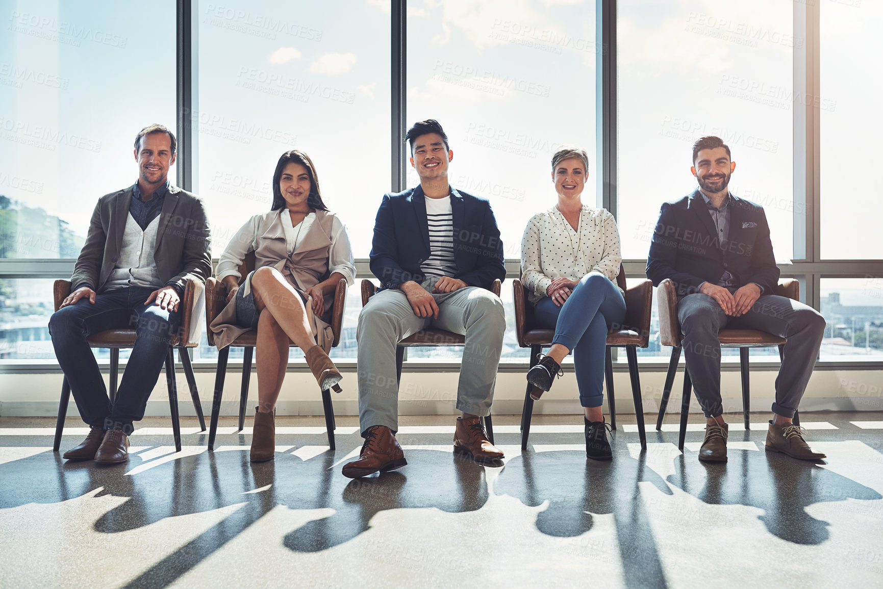 Buy stock photo Portrait of a group of businesspeople sitting in line in an office