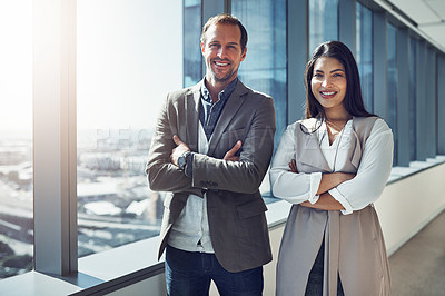 Buy stock photo Portrait of two businesspeople standing with their arms crossed in an office