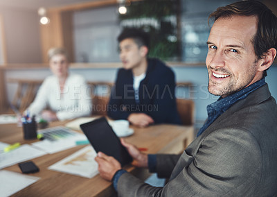 Buy stock photo Portrait of a mature businessman using a digital tablet while in a meeting in an office