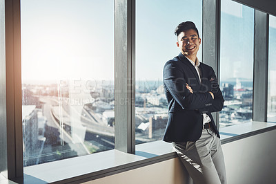 Buy stock photo Portrait of a young businessman standing at a window in an office