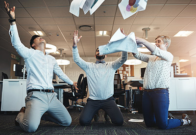 Buy stock photo Shot of businesspeople throwing paperwork in the air in the office