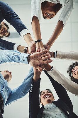 Buy stock photo Hands stacked and piled showing team unity, strength or motivation among creative business colleagues from below. Excited, laughing and huddled group of inspired business people ready for success