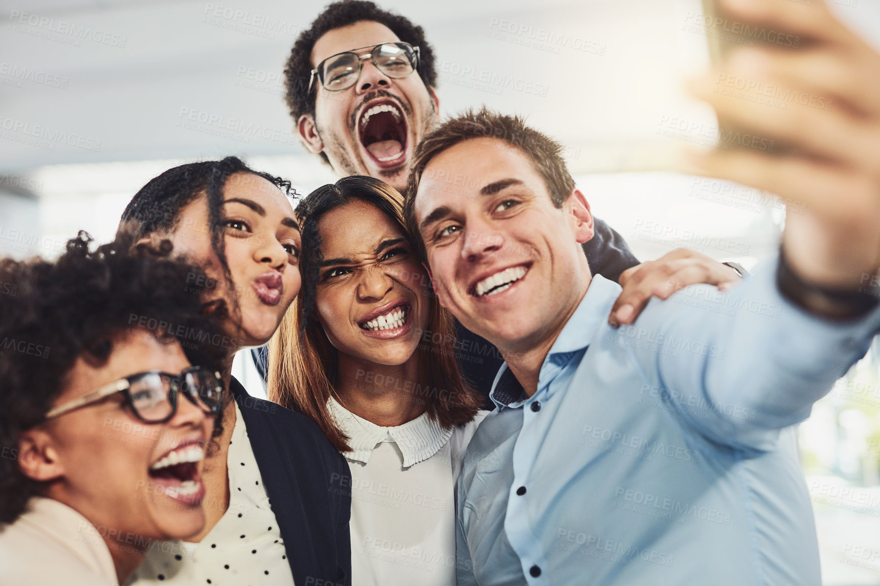 Buy stock photo Teamwork, playful and selfie while a group of cheerful businesspeople making funny faces together for a social media post. Faces of a happy and fun team standing together in a creative office