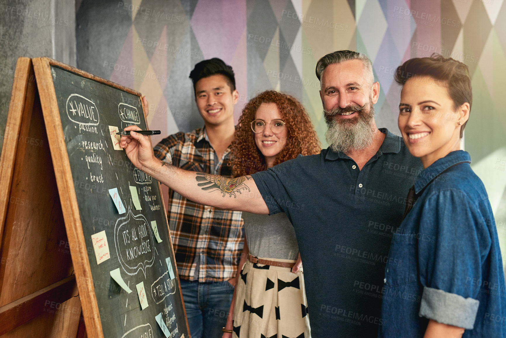 Buy stock photo Cropped shot of creative colleagues brainstorming at a blackboard in a modern office