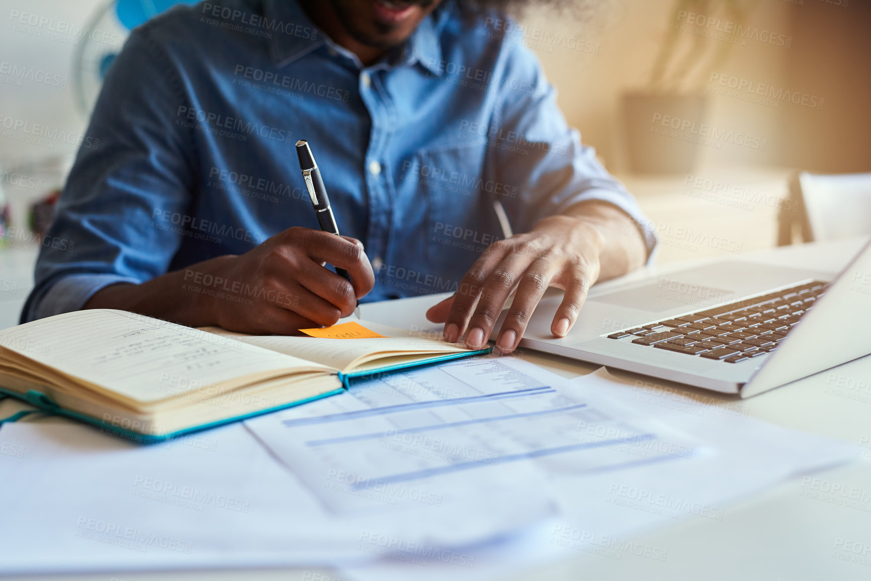 Buy stock photo Cropped shot of an unrecognizable male designer taking notes while working in his office